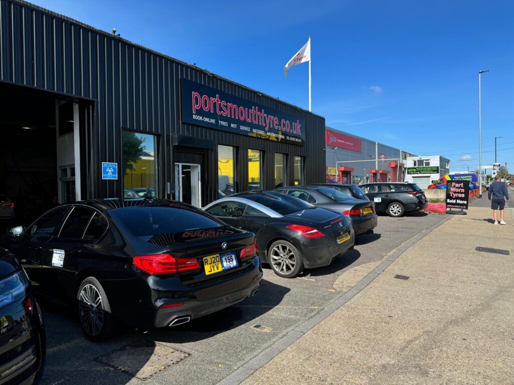 Cars having tyres fitted outside of a tyre shop business
