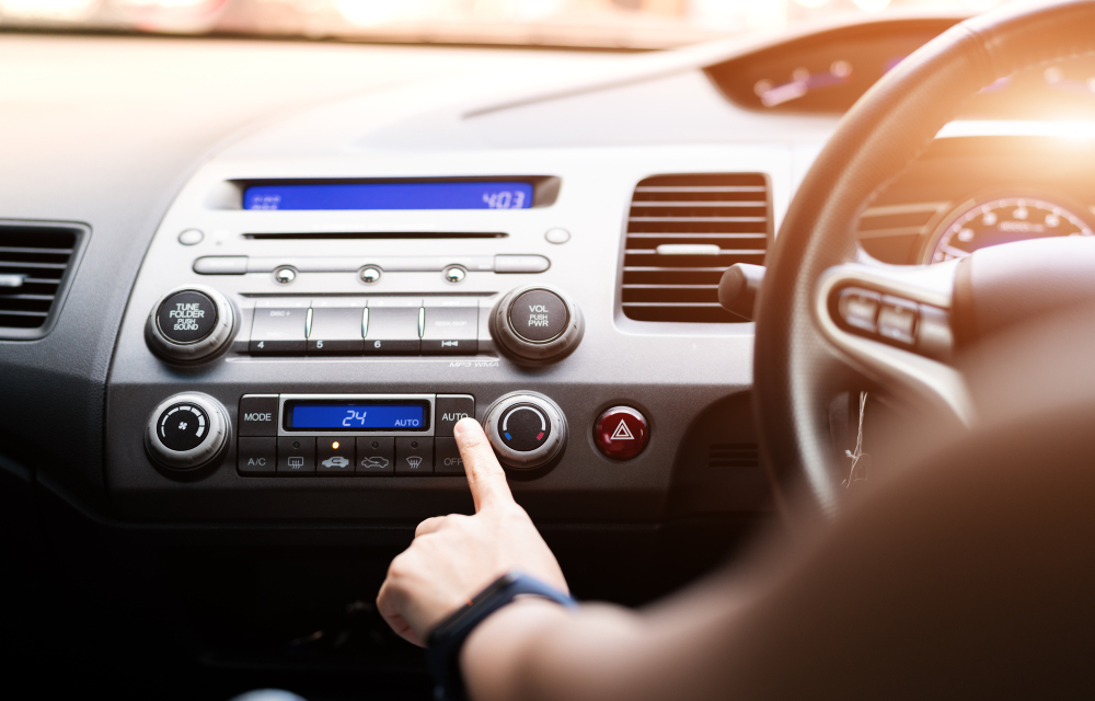 Person pressing aircon button in car